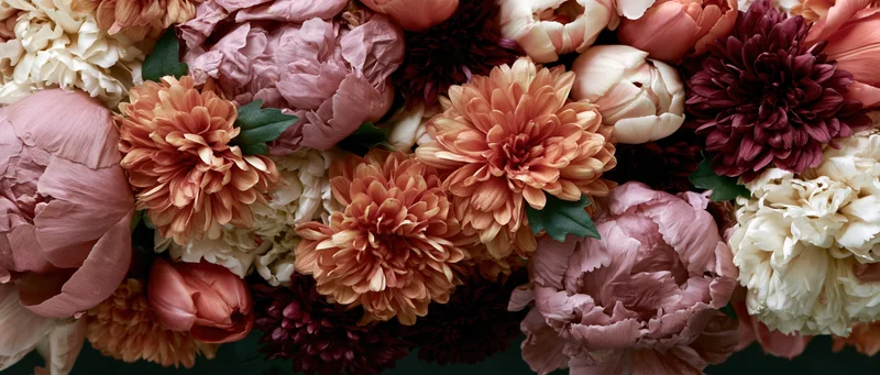 Dense mixed flower arrangement in soft pastel tones filling the frame