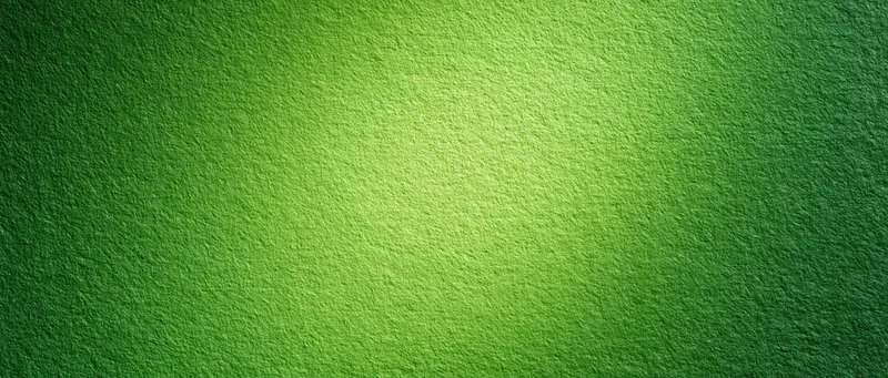 Close-up of green painted textured paper surface with gradient lighting and soft shadows