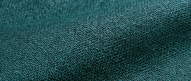 Close-up of dark forest green linen fabric with visible weave pattern filling the frame