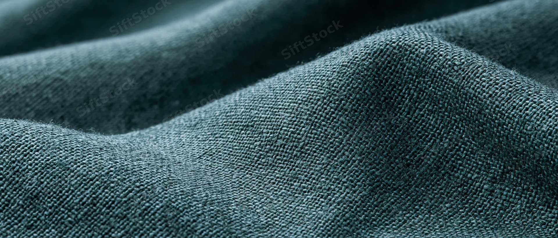 Close-up of dark forest green linen fabric with visible weave and texture filling the frame
