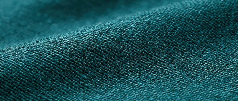 Close-up of dark forest green linen fabric showing woven texture and natural weave pattern
