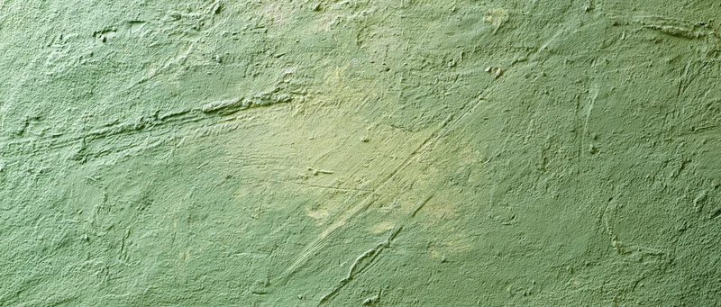 Close-up of a rough green plastered wall with visible texture and imperfections