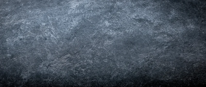 Close-up of aged concrete wall surface with rough texture and dark gray tones