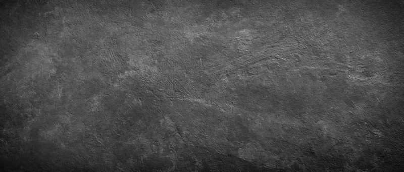 Close-up of aged concrete wall surface with rough texture and dark gray tone