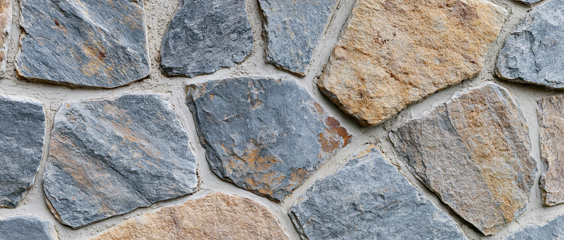 Close-up of irregular dry-stack stone wall with natural stones and mortar joints