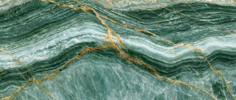 Close-up of polished green marble surface with golden veining and natural patterns