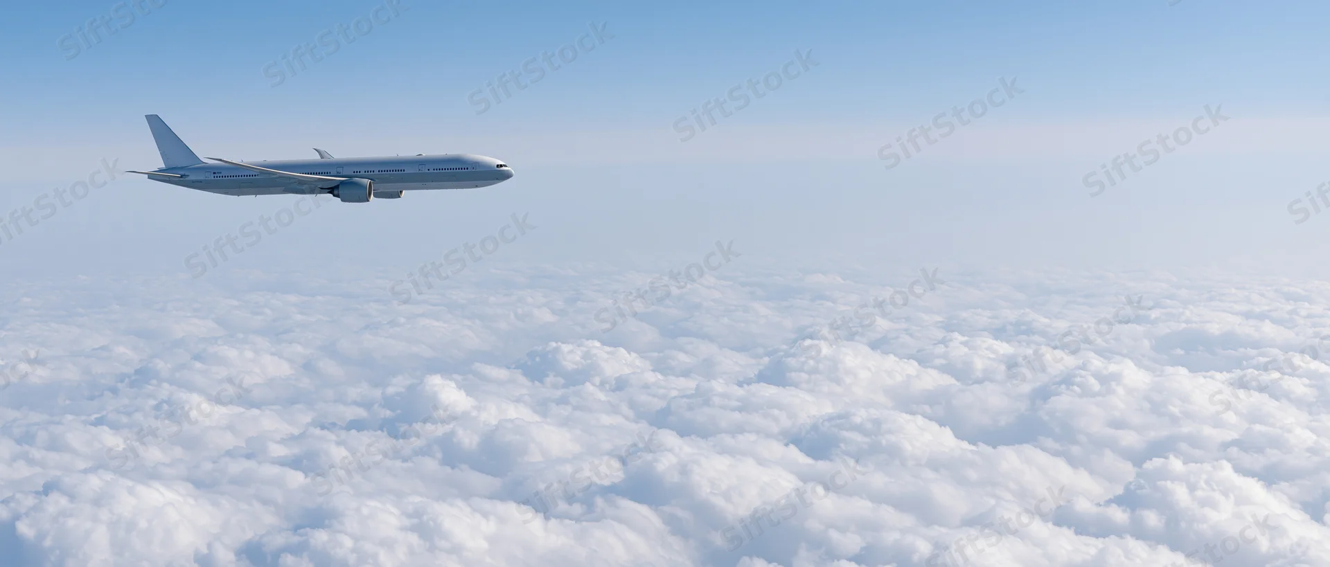 Commercial passenger jet cruising above dense cloud layer in clear sky