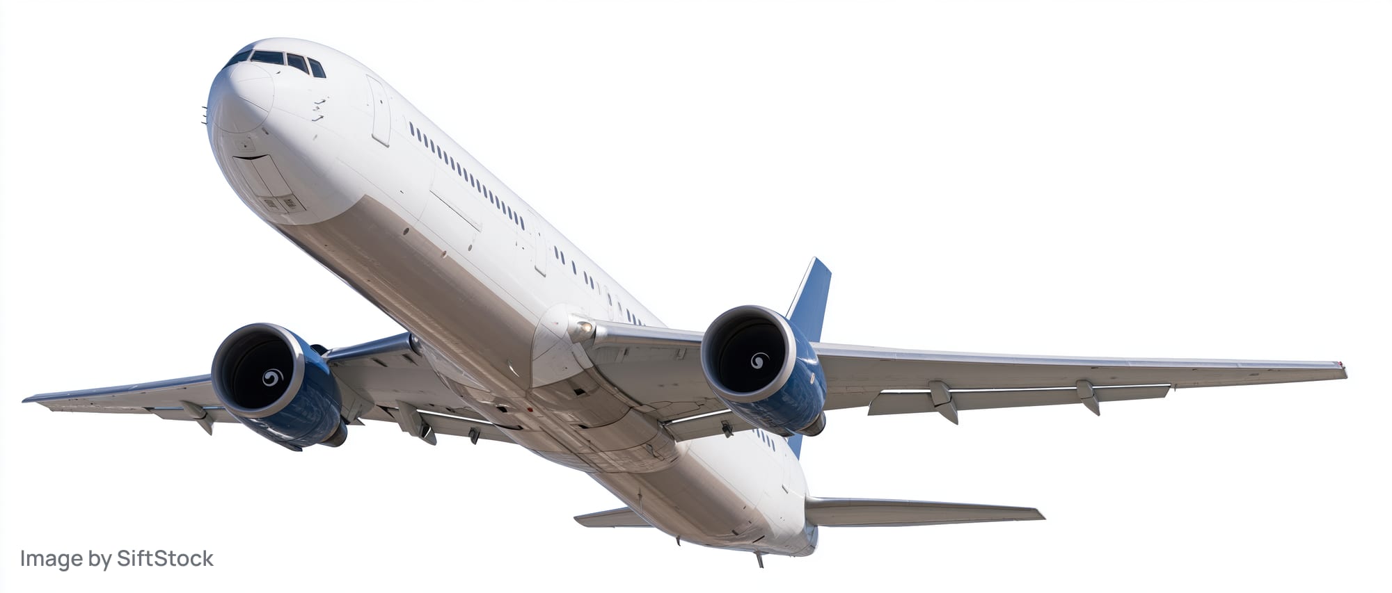 White commercial jet in flight viewed from below against plain white background