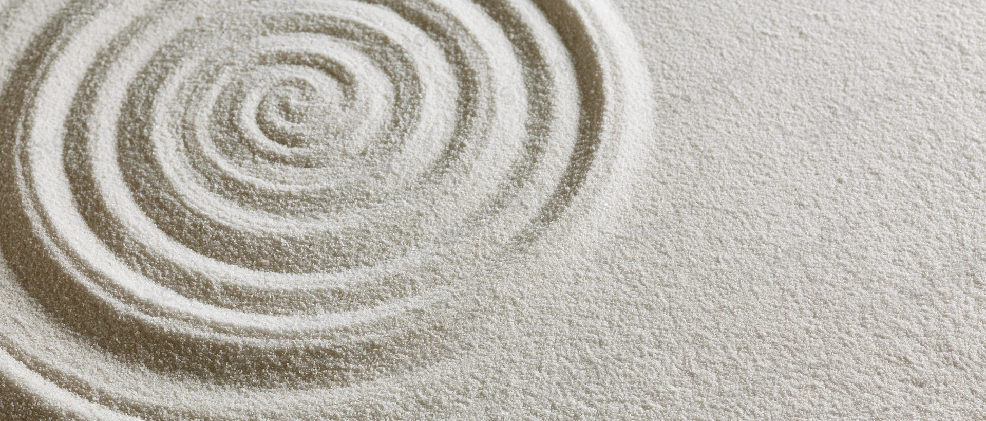 Concentric circles raked into fine white sand in a zen garden