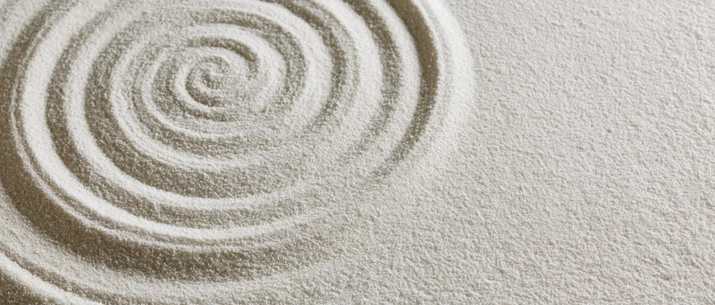 Concentric circles raked into fine white sand in a zen garden