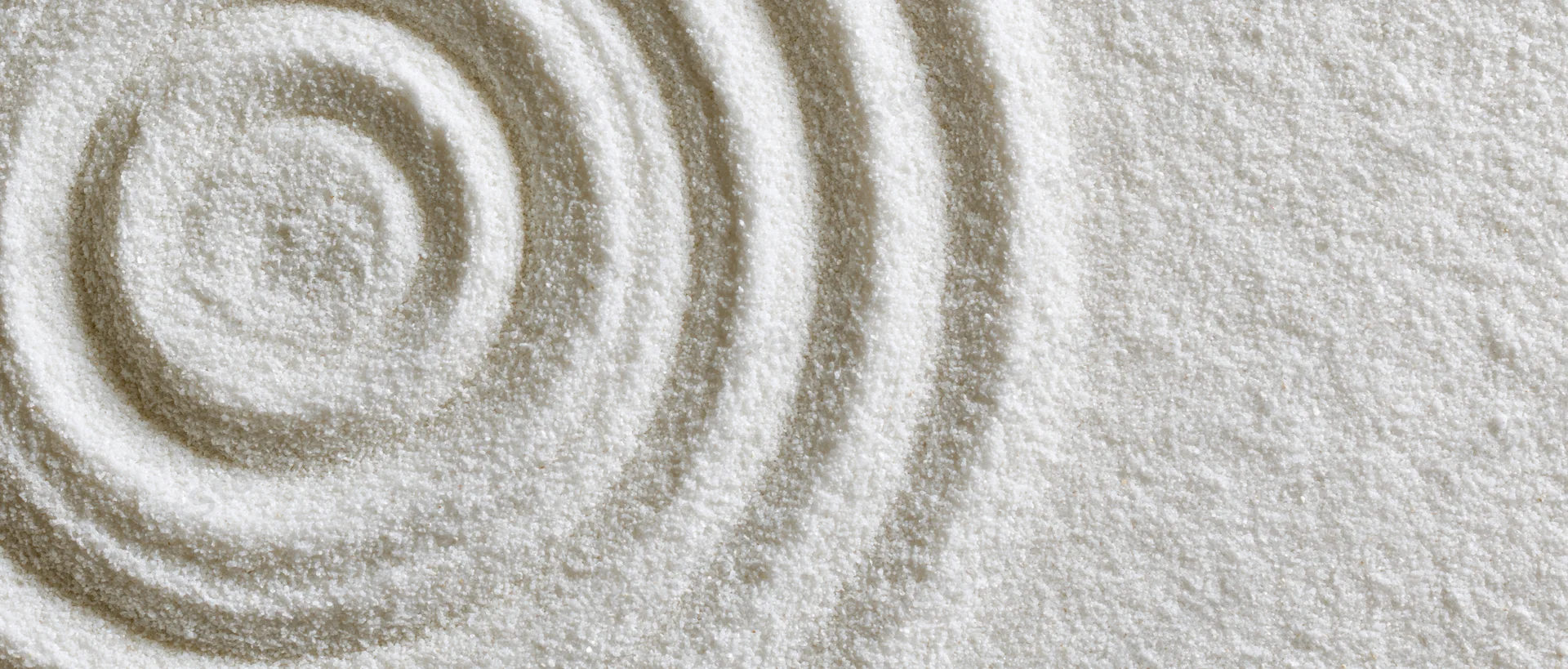 Concentric circles raked into fine white sand in a zen garden pattern