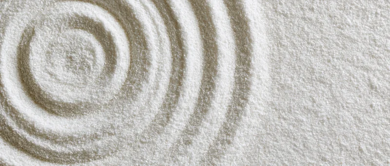 Concentric circles raked into fine white sand in a zen garden pattern