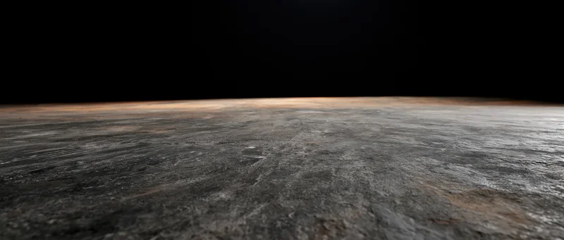 Dark concrete floor receding into black background with visible texture and depth