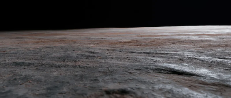 Dark concrete floor receding into black background with visible texture and depth