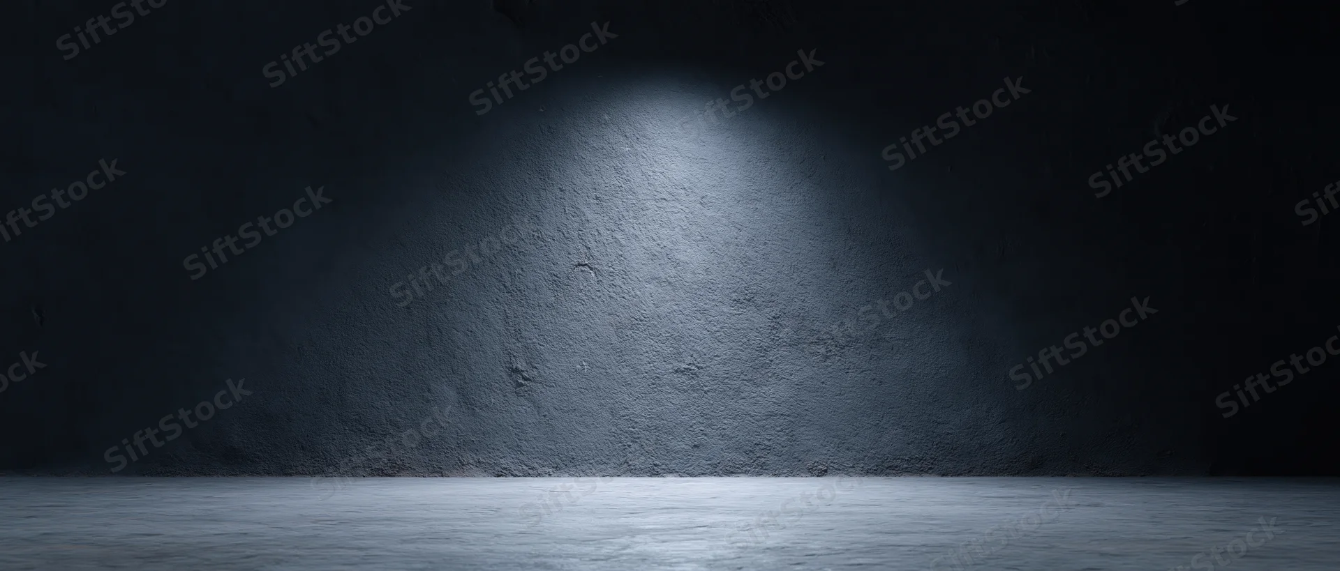 Spotlight on rough concrete wall in dark empty studio room