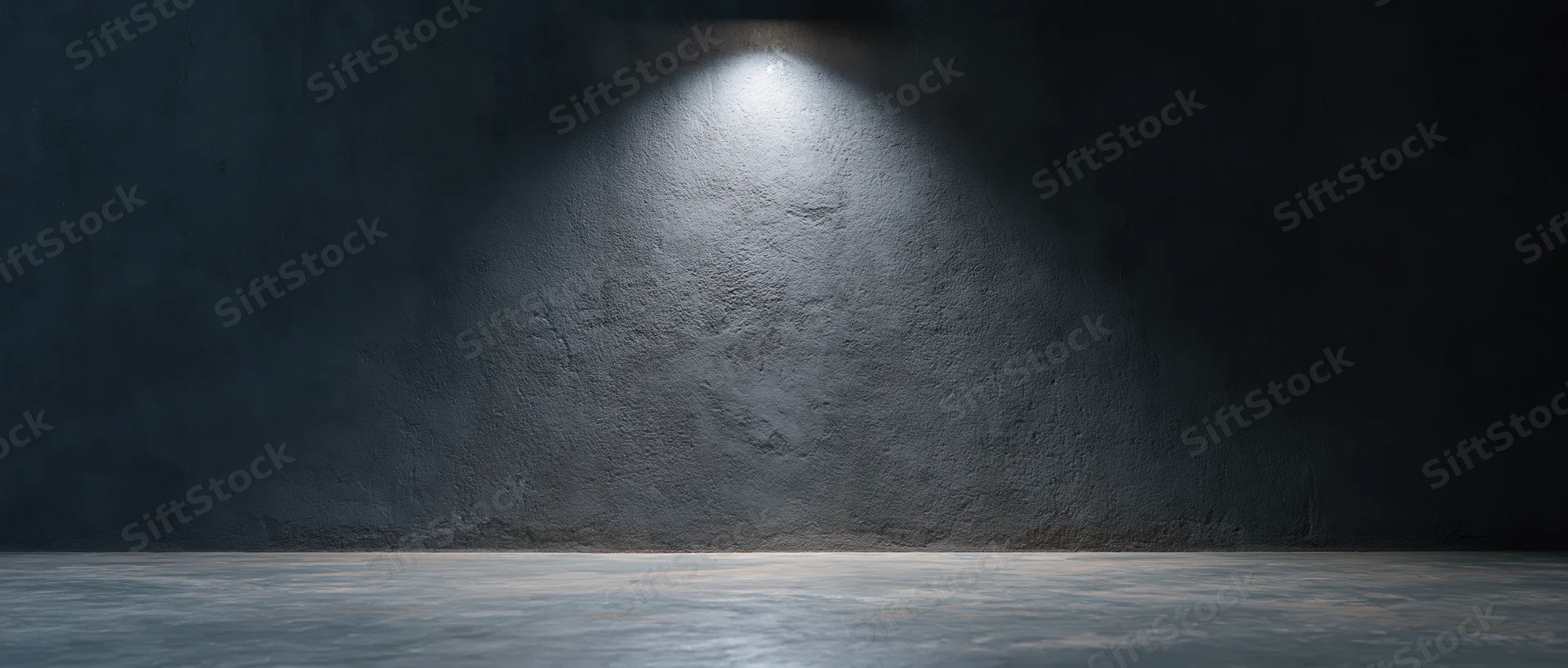Spotlight on rough concrete wall in dark empty studio room