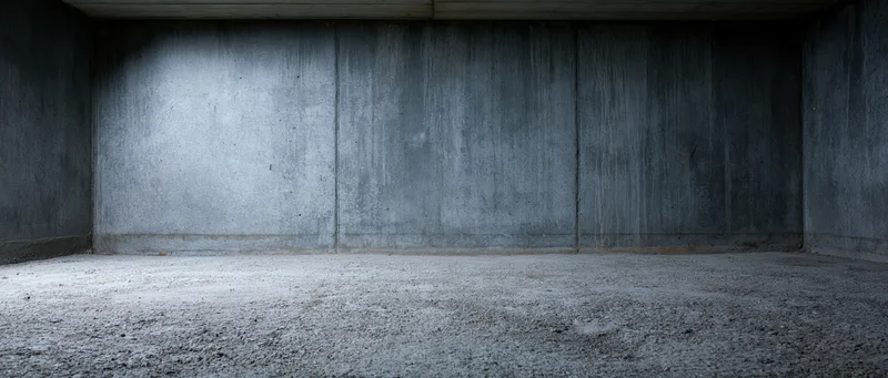 Empty industrial interior with bare concrete walls and floor