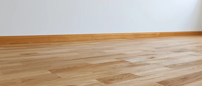 Light oak hardwood parquet flooring in an empty interior room