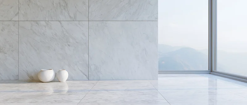Minimalist interior with white marble walls and floor, large window overlooking mountains, two small vases on the floor