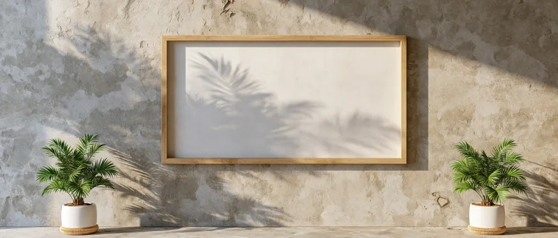 Empty wooden frame hanging on weathered concrete wall with potted plants casting shadows