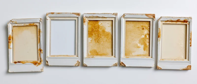 Five empty vintage photo frames arranged in a horizontal row on a white background