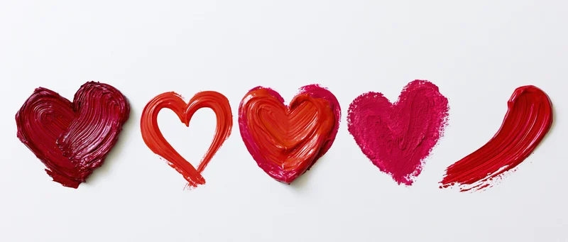 Five hand-painted red hearts in a horizontal row on white background