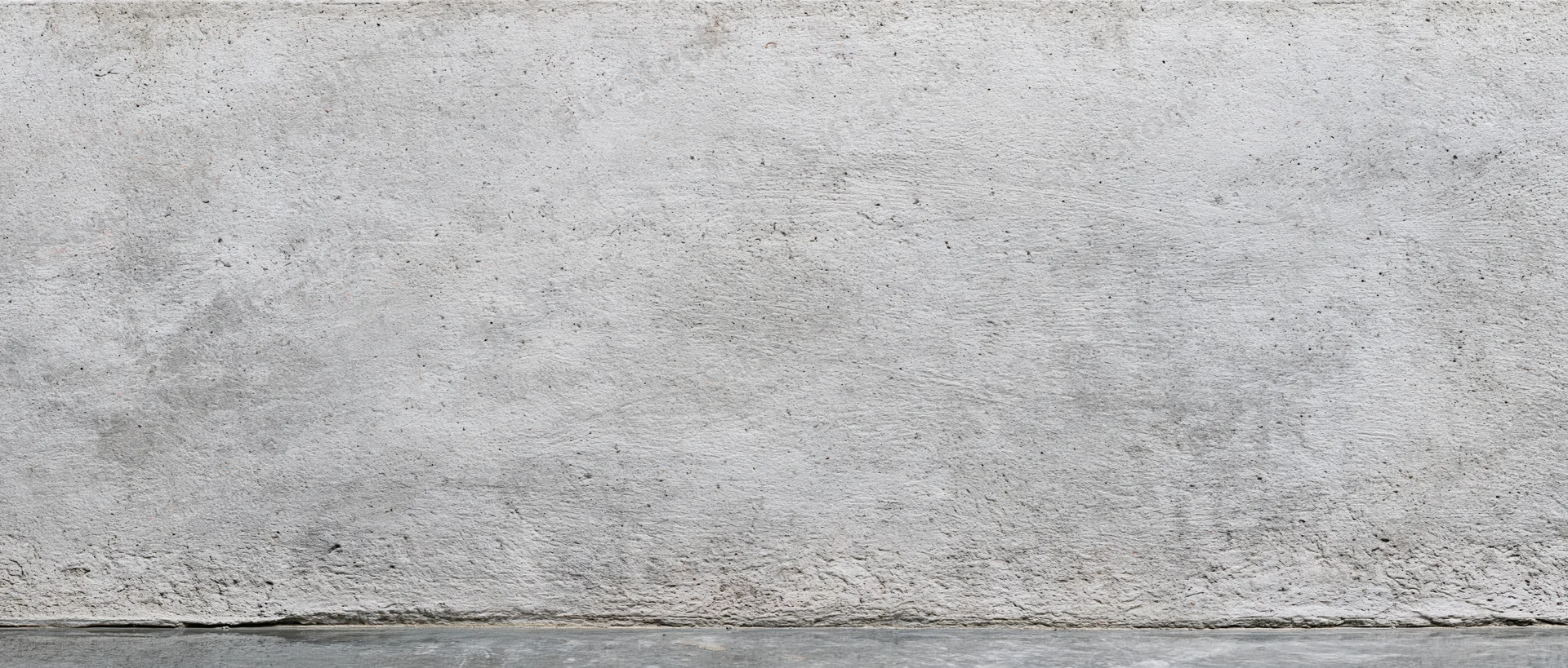 Wide flat concrete wall surface with rough texture and gray tone