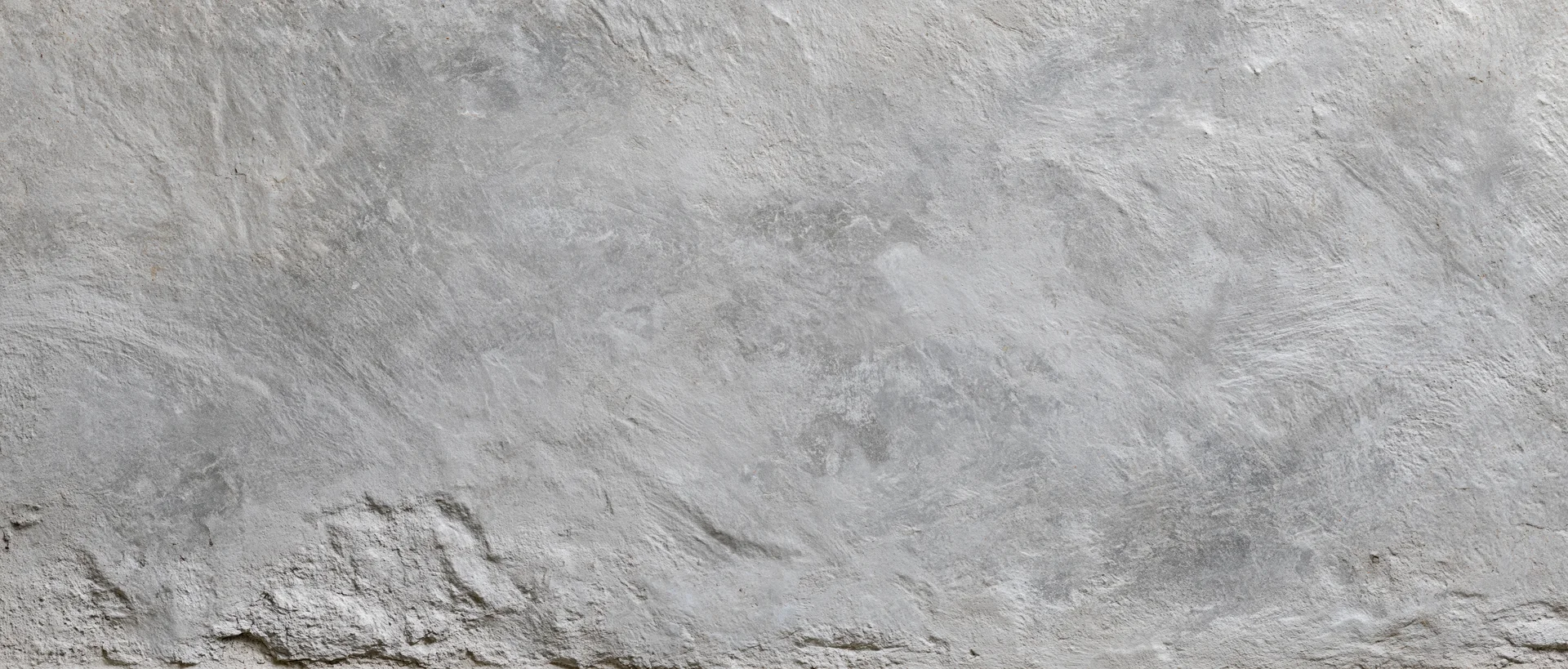 Close-up of a rough gray concrete wall surface with visible texture and imperfections