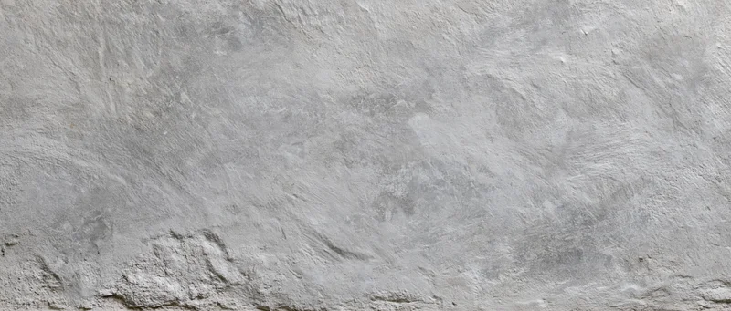 Close-up of a rough gray concrete wall surface with visible texture and imperfections