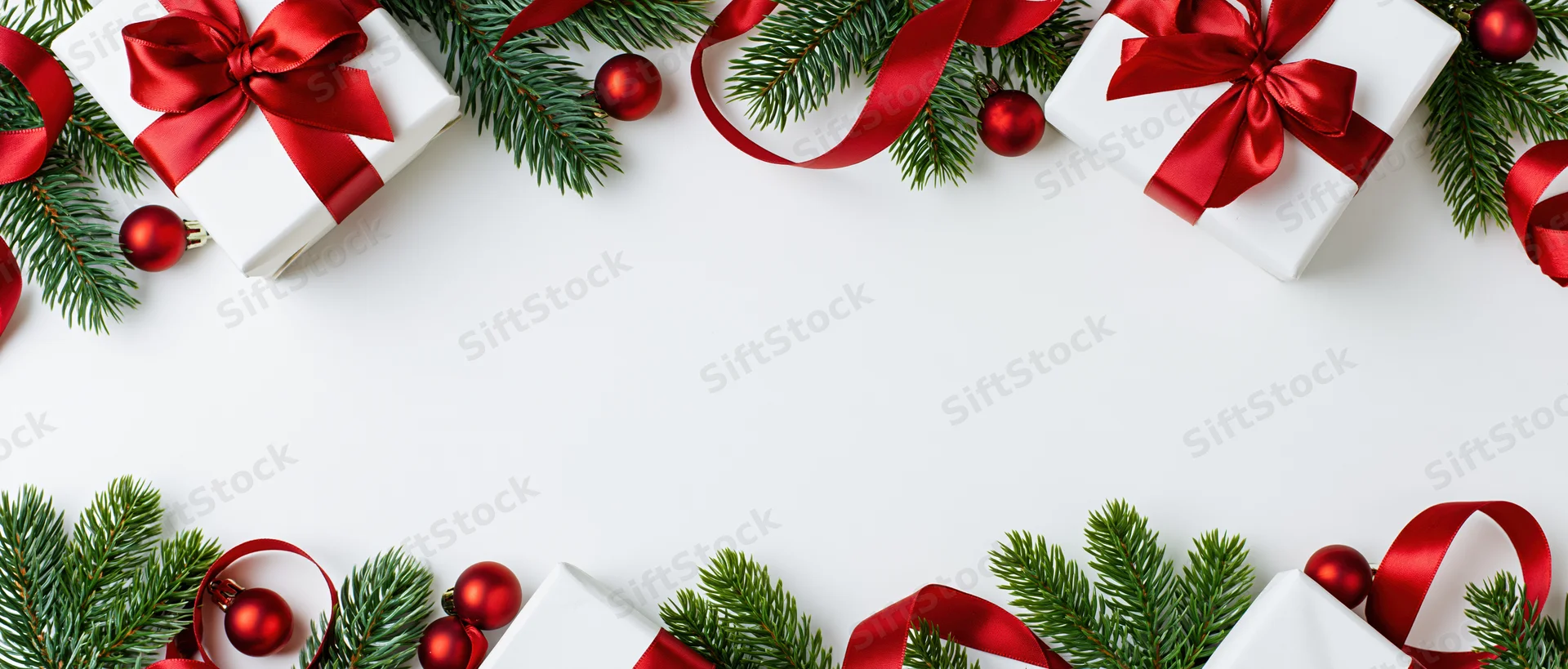 Christmas border arrangement with gifts, pine branches and red ribbons on white surface