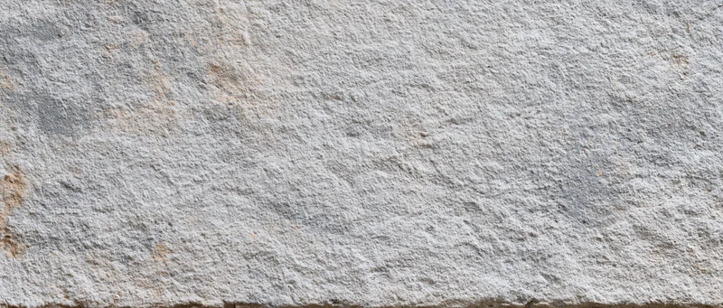 Close-up of a rough gray concrete wall surface with natural texture and subtle color variations
