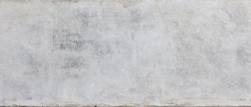 Close-up of a weathered concrete wall surface with rough texture and gray tones