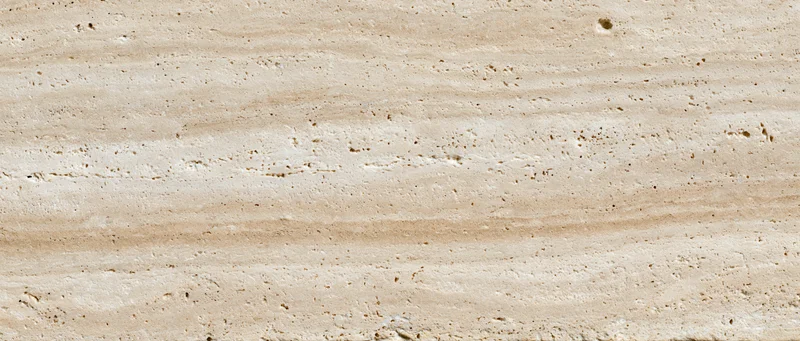 Close-up of polished travertine stone surface with natural striations and texture