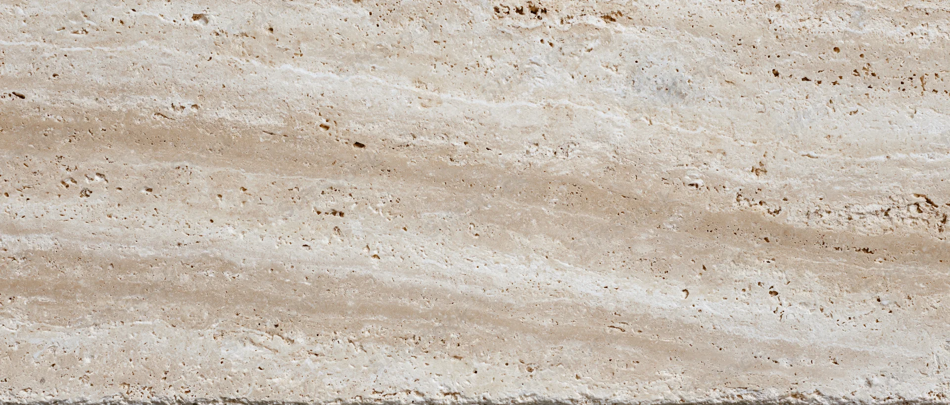 Close-up of a polished travertine stone surface with natural veining and texture