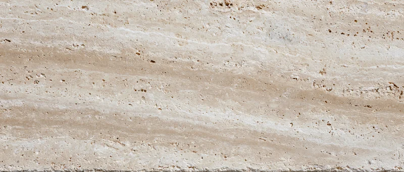 Close-up of a polished travertine stone surface with natural veining and texture