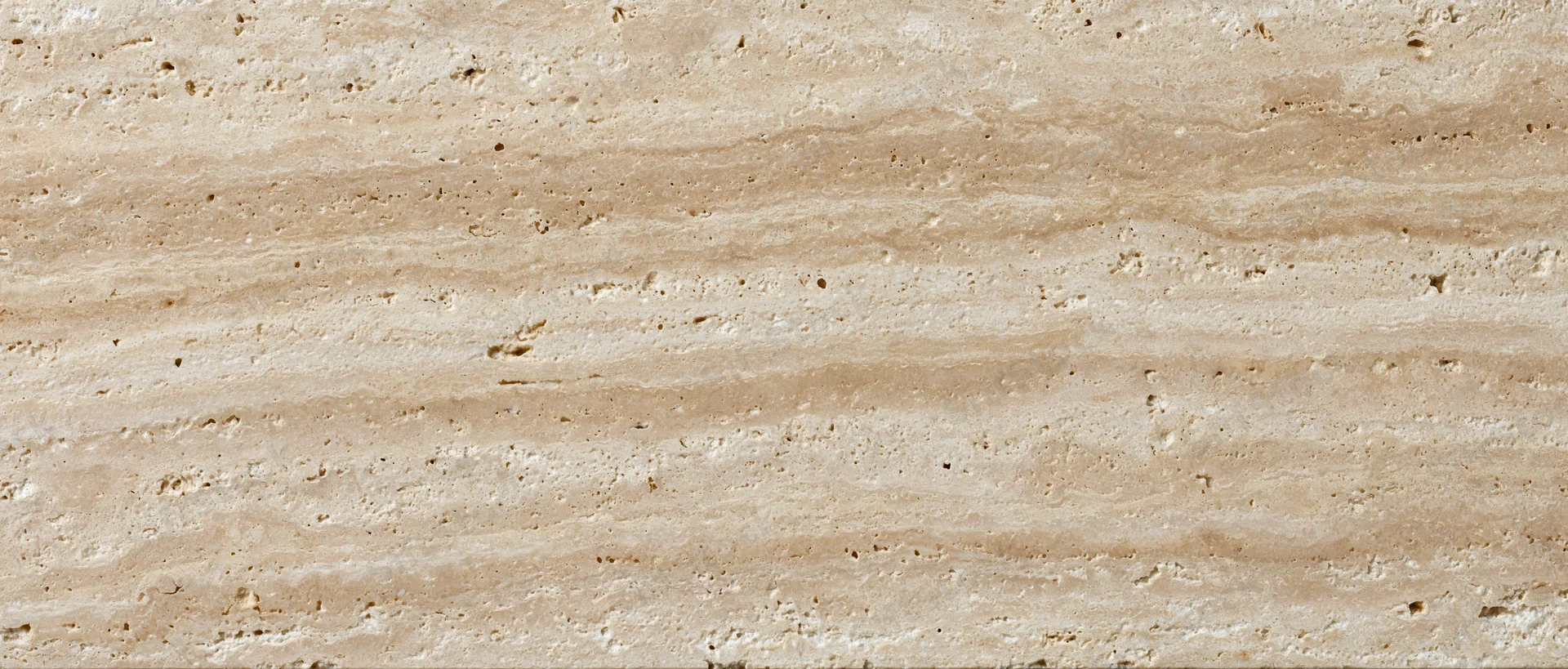 Close-up of polished travertine stone surface with natural veining and texture