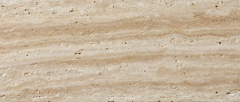 Close-up of polished travertine stone surface with natural veining and texture