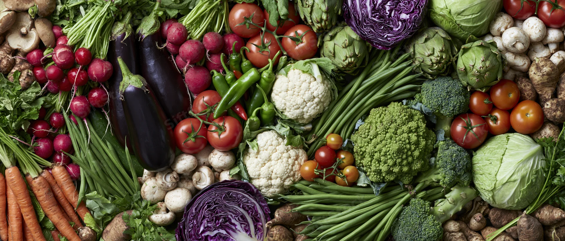 Overhead flat lay of densely packed fresh raw vegetables filling the frame