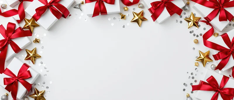 White gift boxes with red satin ribbons and gold stars arranged in a border around a blank center space