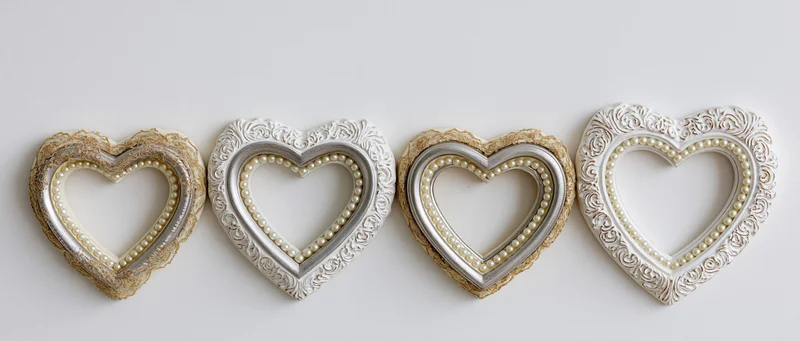 Four heart-shaped decorative frames arranged horizontally on a white surface