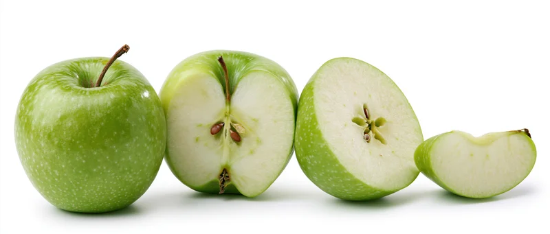 Four green apples in a row, whole and sliced, on white background