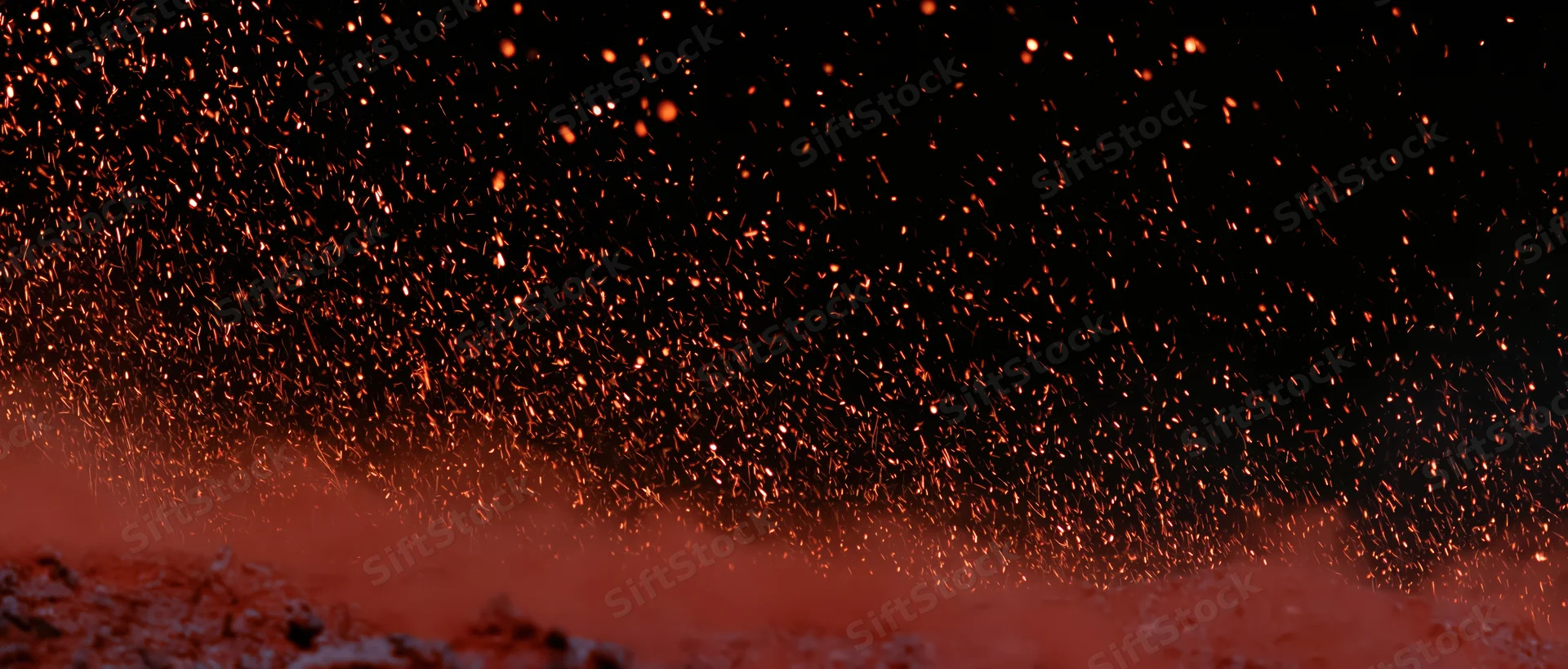 Glowing sparks rising upward against a dark background