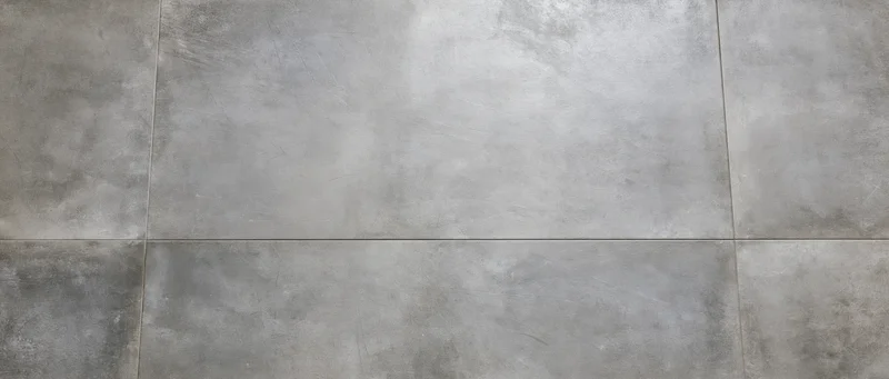 Large-format concrete floor tiles viewed from directly above in an interior space