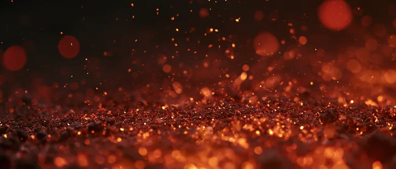 Glowing embers and sparks rising from a dark surface at night