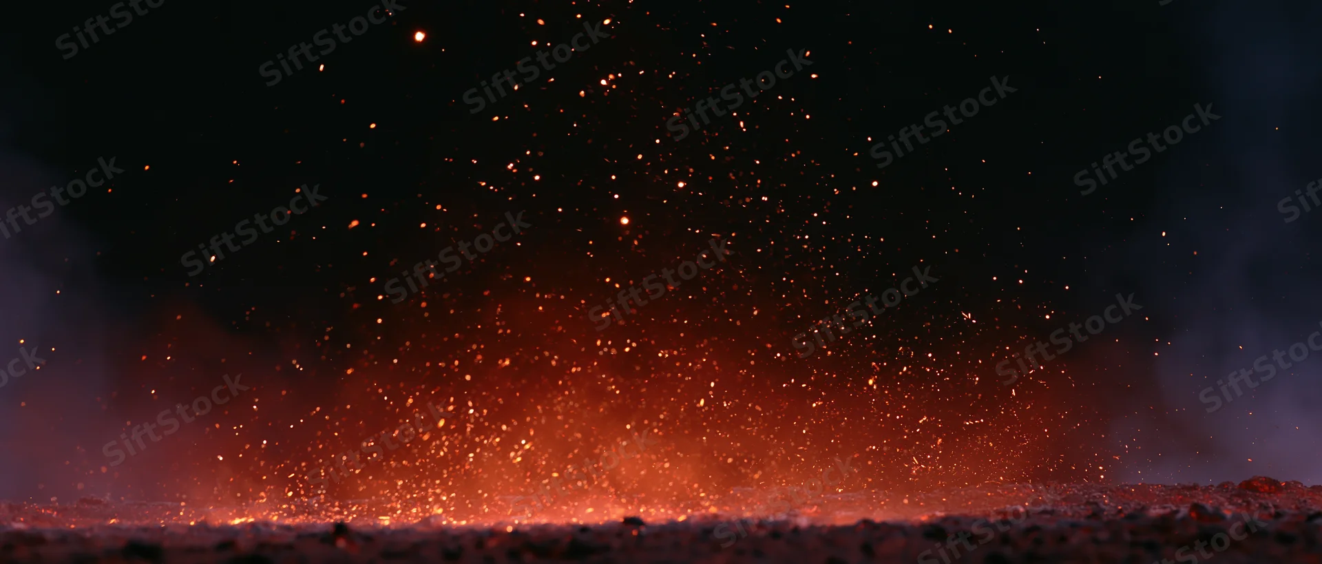 Fiery sparks rising from burning ground at night
