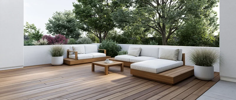 Modern outdoor patio with teak wood deck and white cushioned lounge furniture surrounded by greenery