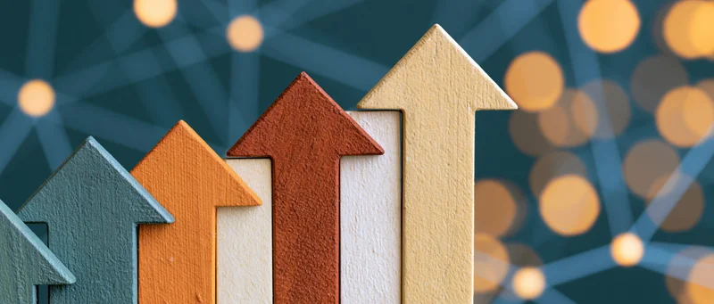 Row of wooden arrows pointing upward in ascending order against a digital network background with bokeh lights