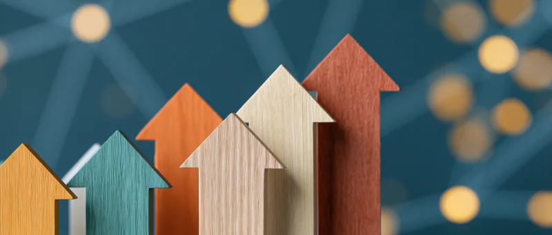 Wooden arrows pointing upward in a row against a blue networked background with bokeh lights