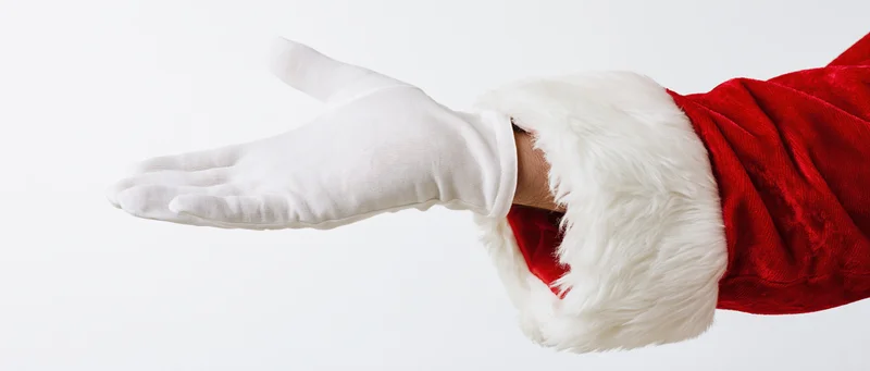Santa claus arm with white glove extended palm outward on white background
