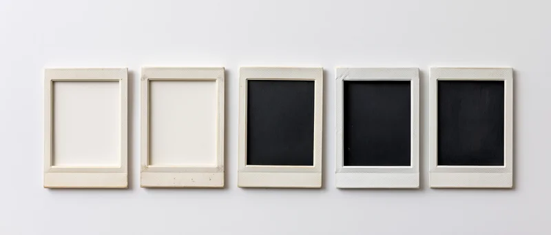 Five blank instant photo frames arranged horizontally on a white surface